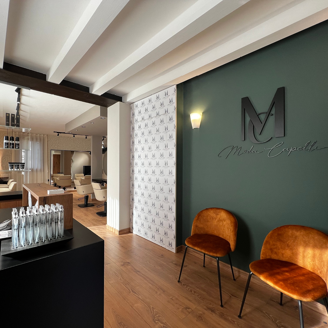 Immagine del bancone della reception, con bancone i legno e davanti due poltrone per salone d'attesa